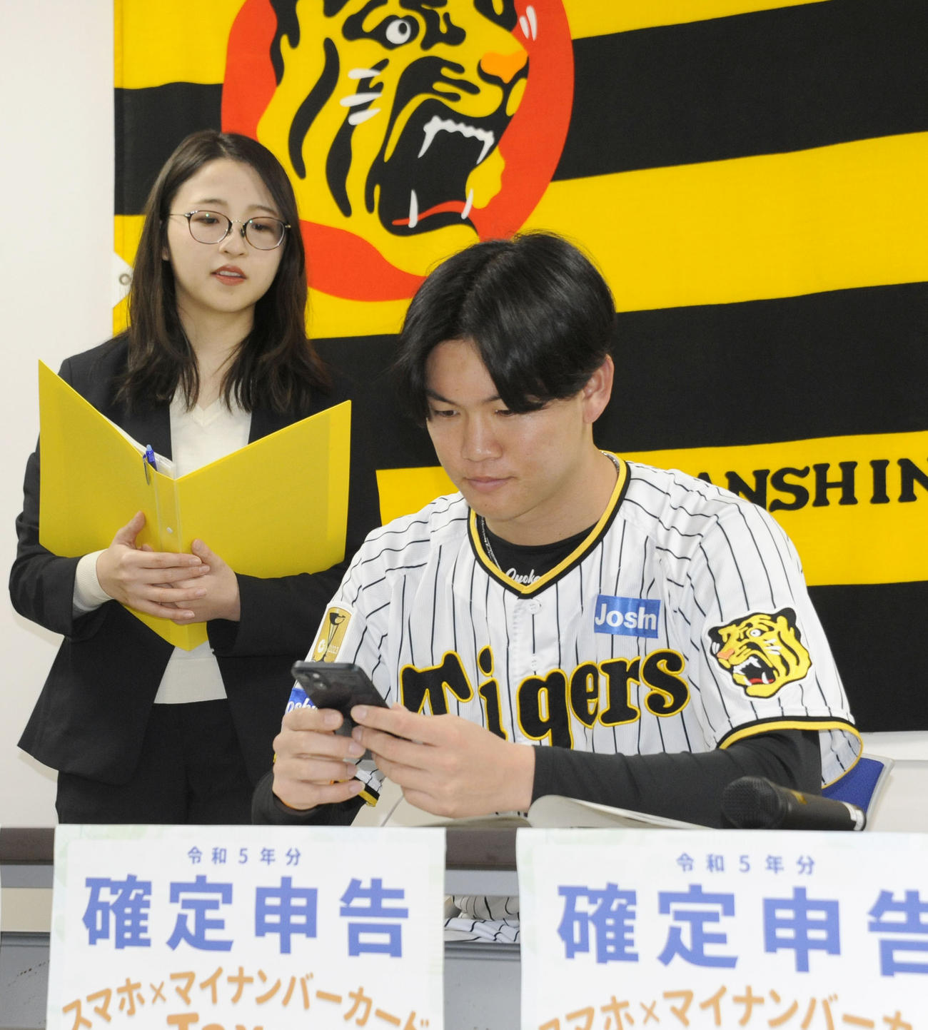 スマートフォンを使った確定申告を模擬体験する阪神の及川雅貴（共同）