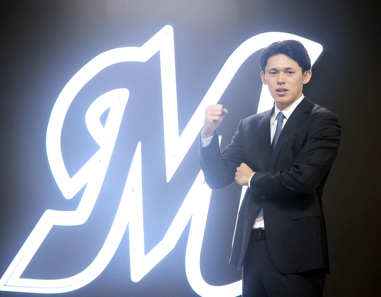 会見を終え、Mのマークを背にガッツポーズするロッテ佐々木（撮影・浅見桂子）