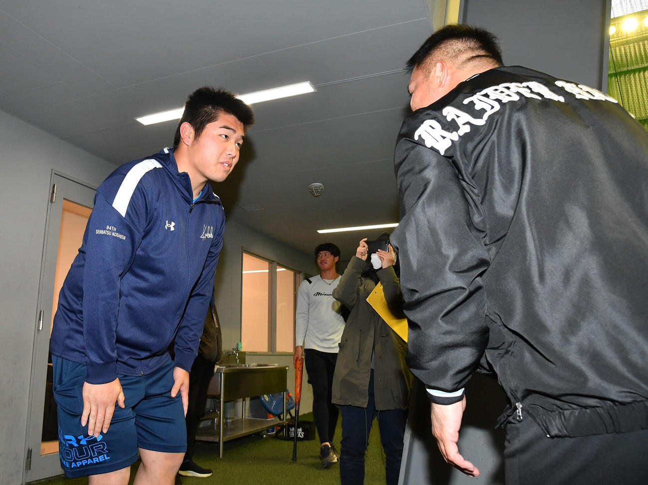 山川（右）にあいさつする佐倉（撮影・岩下翔太）