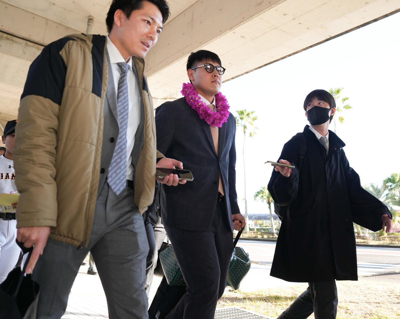 宮崎空港に到着し、バスへ移動する巨人岡本和（中央）（撮影・鈴木みどり）