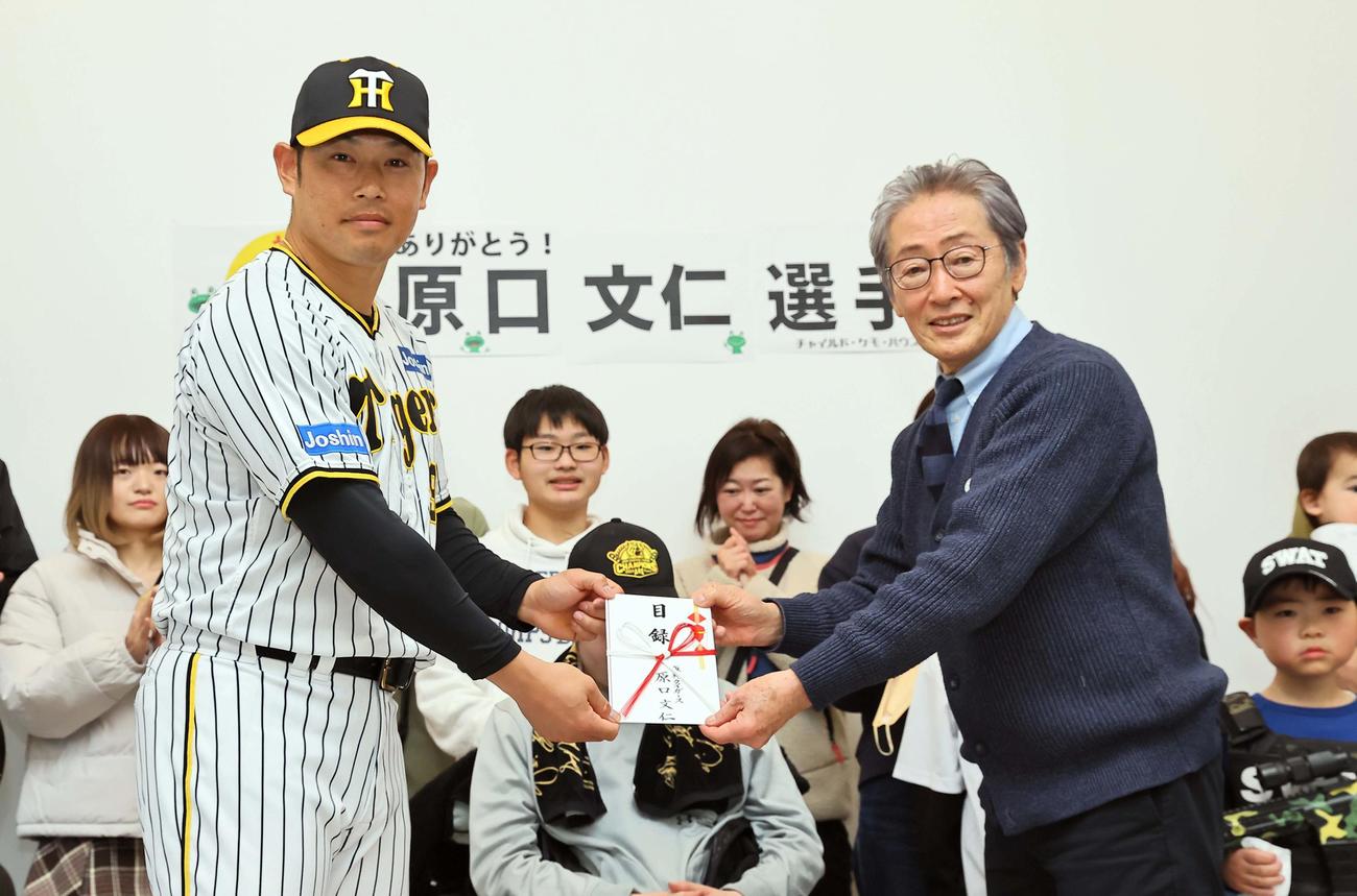 チャイルド・ケモ・ハウス堀内理事長（右）に寄付金を手渡す阪神原口（撮影・上田博志）