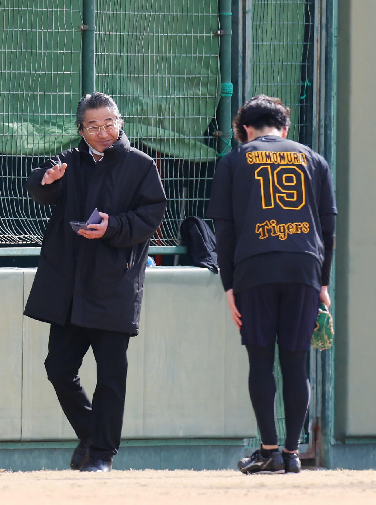 阪神下村（右）からのあいさつに笑顔で応える嶌村球団本部長（撮影・前田充）