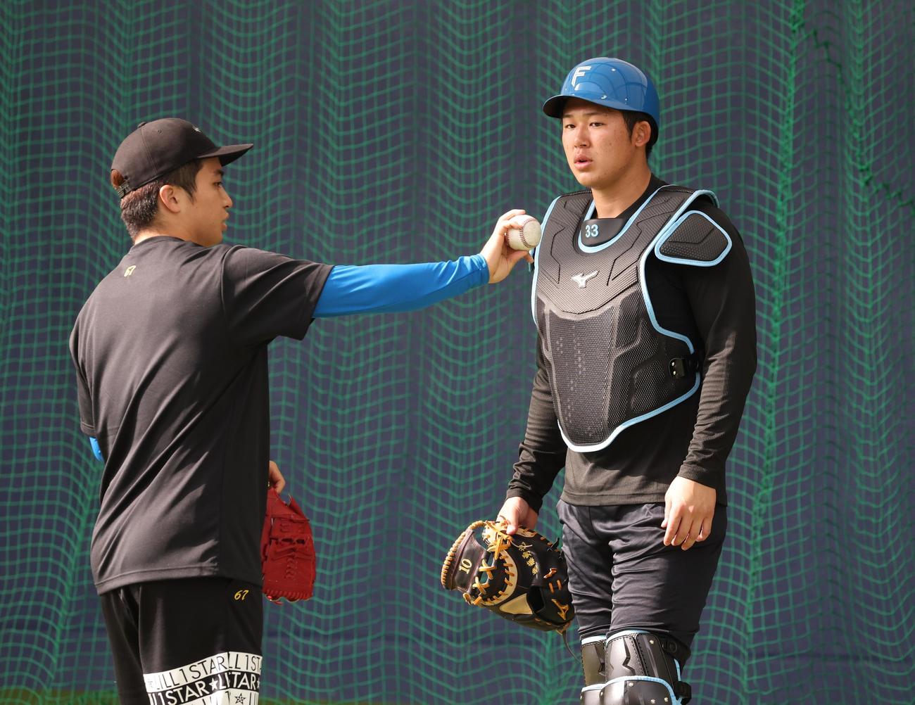 ブルペンで山本拓（左）と話す日本ハム進藤（撮影・黒川智章）