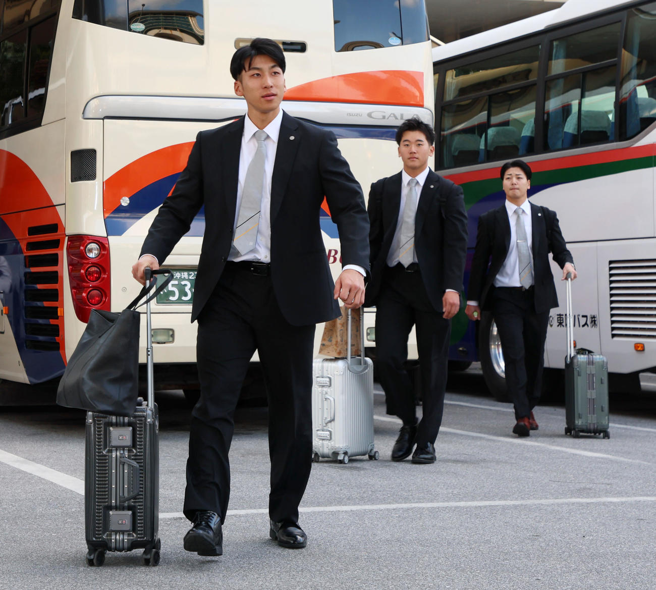 空路で沖縄へ移動しバスへ向かう左から茨木、門別、漆原（撮影・加藤哉）