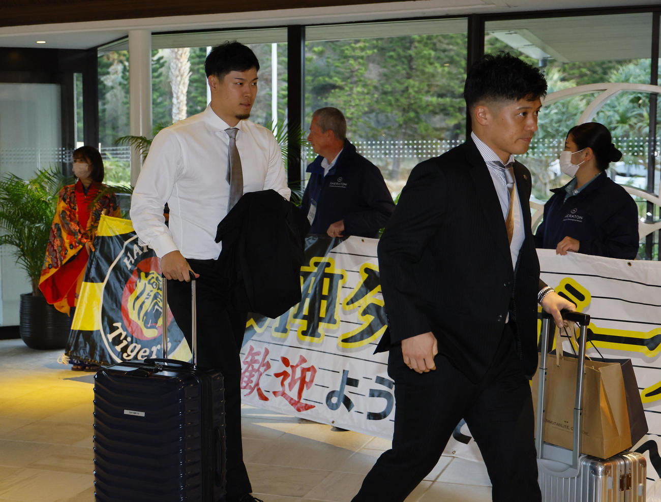 合同自主トレのため沖縄入りし、宿舎に到着した佐藤輝（左）と坂本（撮影・藤尾明華）