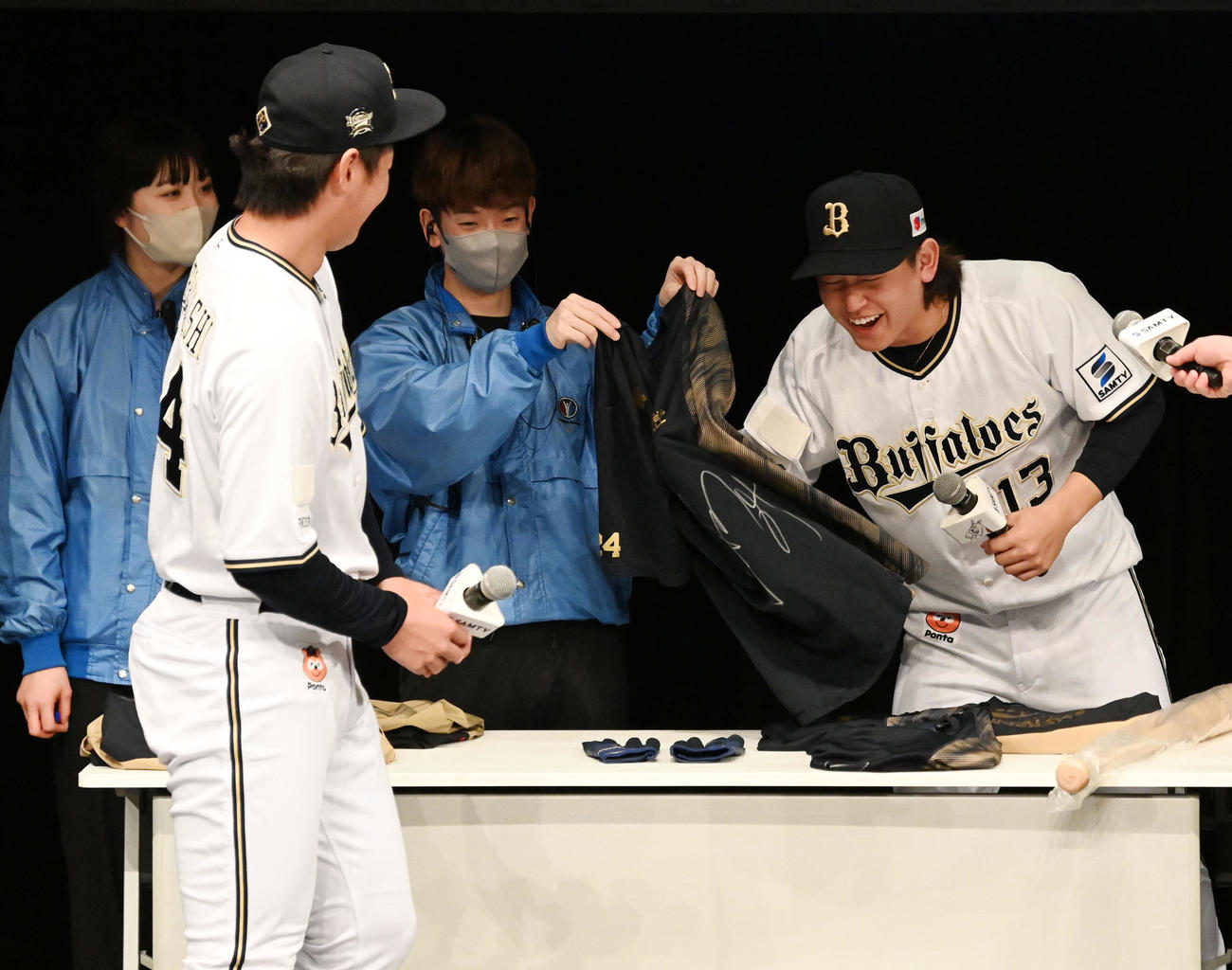 抽選会で紅林（左）からプレゼントされる練習着のにおいを嗅ぐ（撮影・前岡正明）
