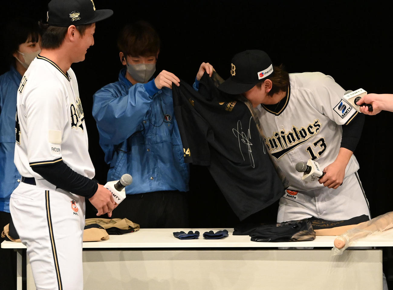 抽選会で紅林（左）からプレゼントされる練習着のにおいを嗅ぐ（撮影・前岡正明）