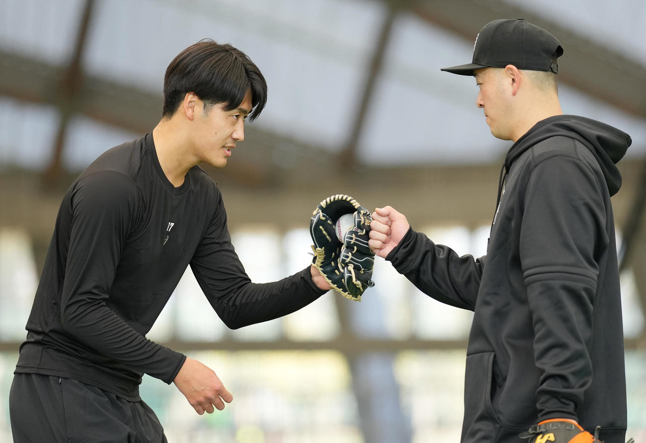 ブルペン投球を終え、岸田（右）とタッチを交わす巨人西舘（撮影・鈴木みどり）