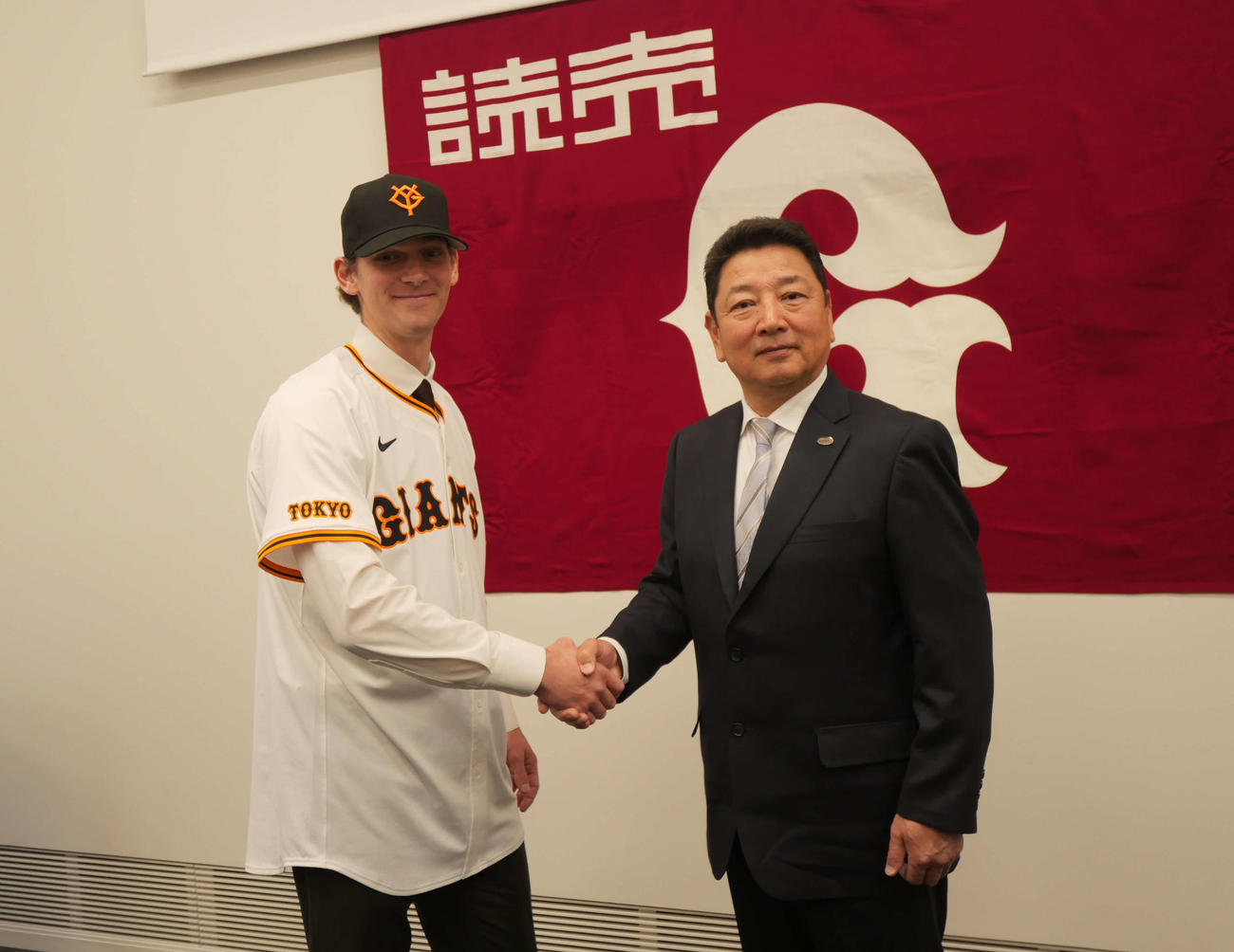 握手をする巨人カイル・ケラー（左）と吉村編成本部長（撮影・上田悠太）