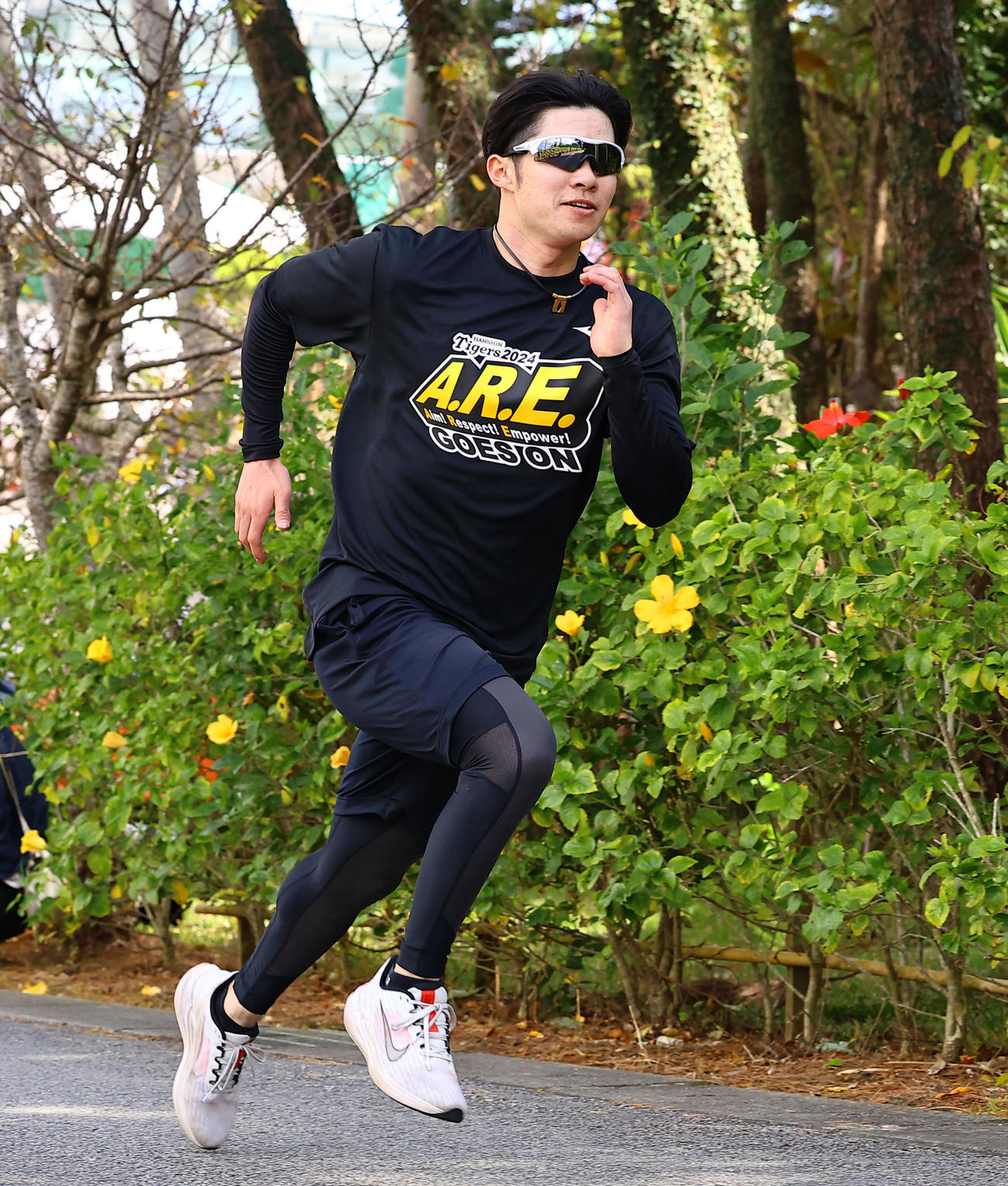 黄色いハイビスカスの横を坂道ダッシュする中野（撮影・藤尾明華）