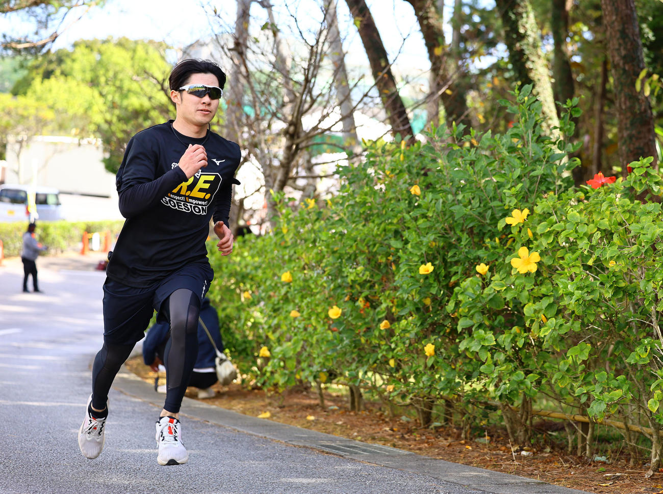 黄色いハイビスカスの横を坂道ダッシュする中野（撮影・藤尾明華）