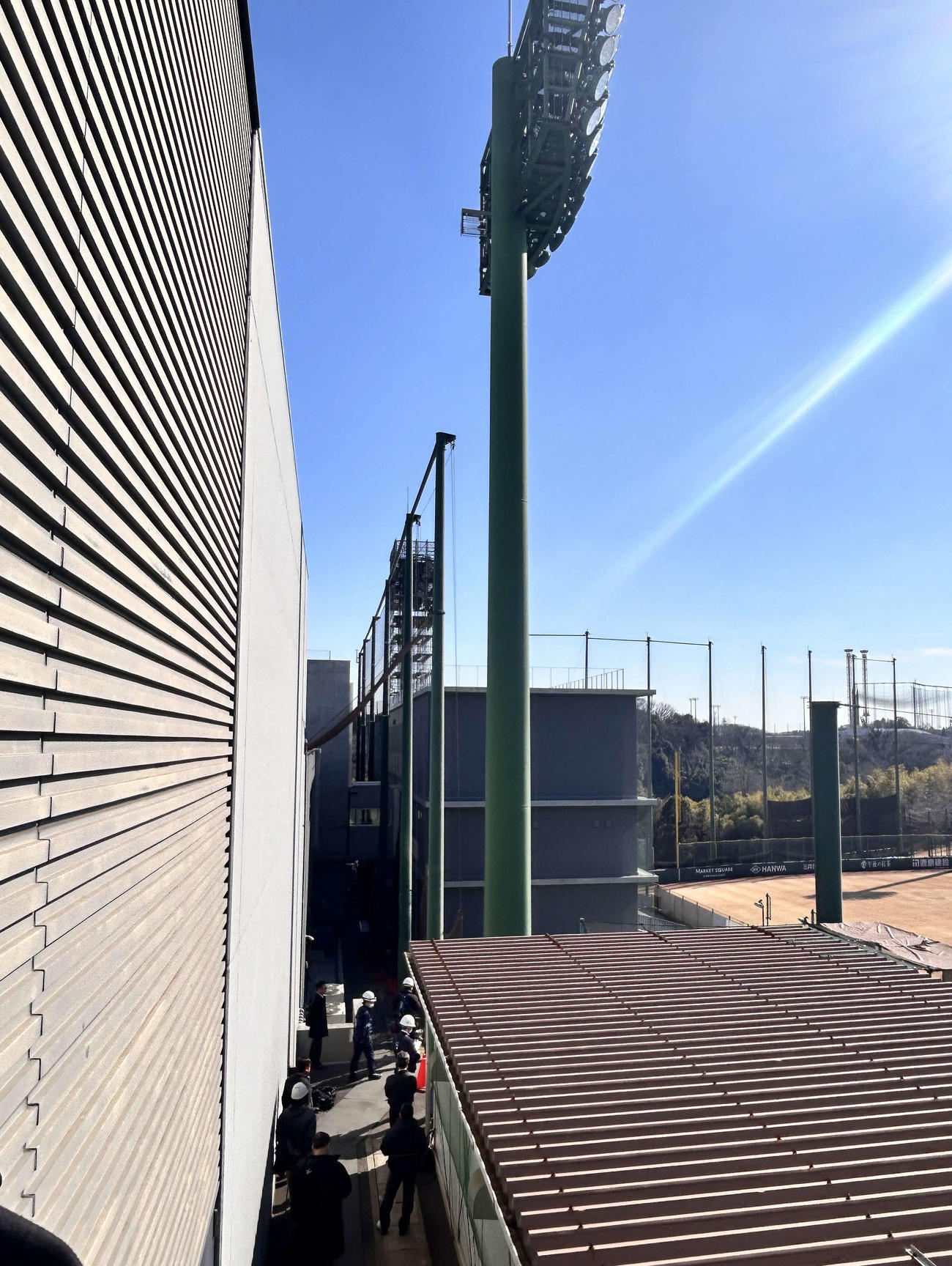 照明機器が落下した事故現場で作業員らが状況を確認する