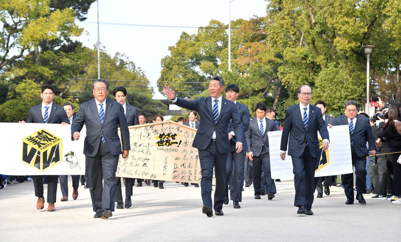 必勝祈願で筥崎宮に到着し、笑顔でファンに手を振りながら本殿へ向かう小久保監督（中央）とソフトバンクナイン（撮影・岩下翔太）