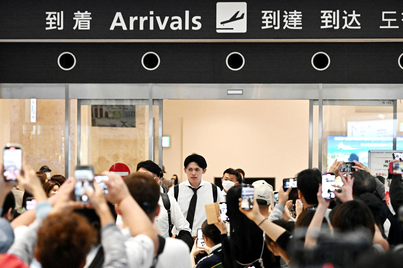 石垣空港に到着しファンに囲まれるロッテ佐々木（撮影・滝沢徹郎）