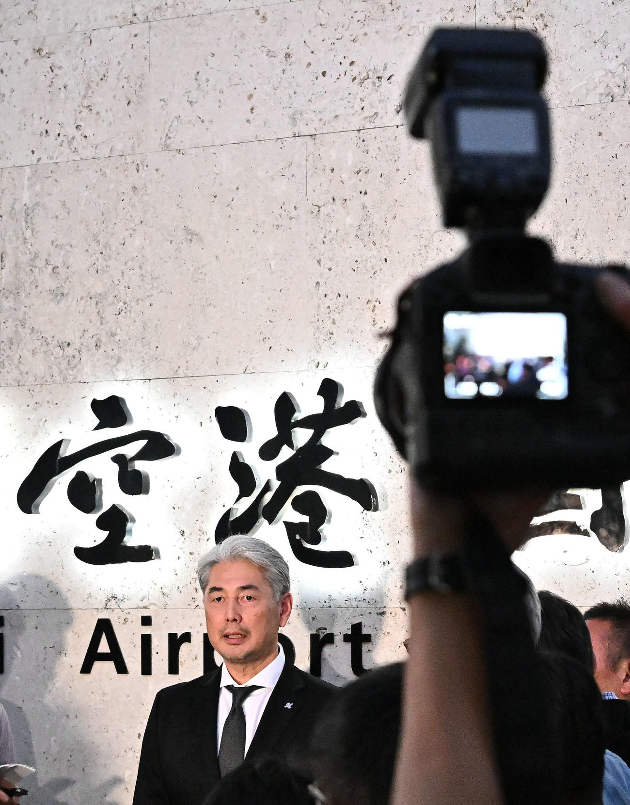 石垣空港に到着し取材に応じるロッテ吉井監督（撮影・滝沢徹郎）