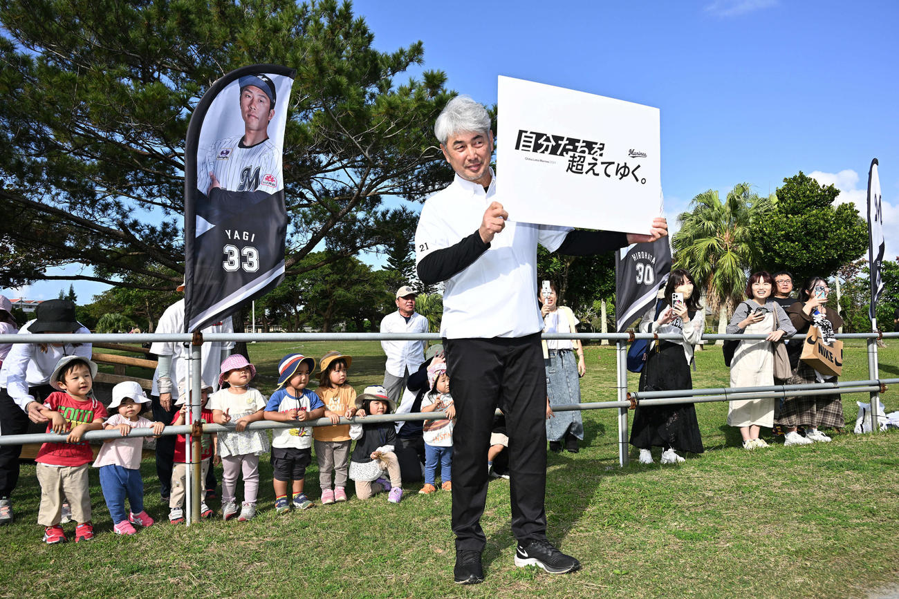 今季のチームスローガン「自分たちを超えてゆく。」のパネルを手に記念撮影するロッテ吉井監督（撮影・滝沢徹郎）