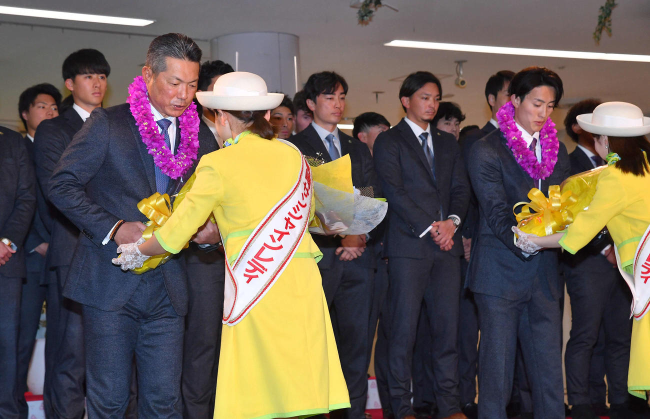 宮崎空港に到着し、歓迎セレモニーで花束を贈呈されるソフトバンク小久保紀裕監督（左）と周東佑京（撮影・岩下翔太）