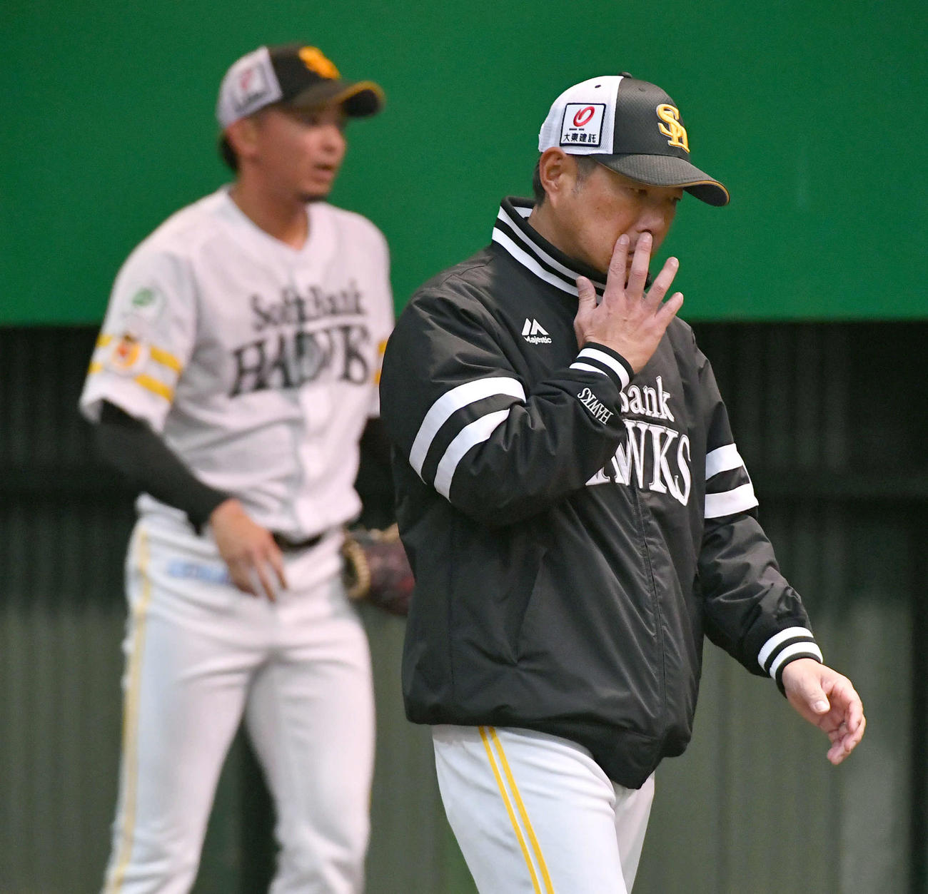 ブルペンでマウンド付近から捕手側へ移動するソフトバンク小久保監督。左は東浜（撮影・岩下翔太）