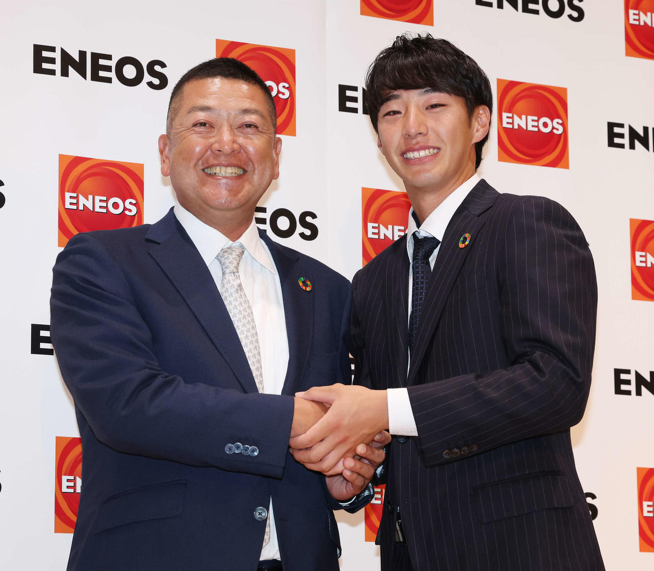 DeNAから1位指名を受け、ENEOS・大久保監督（左）と笑顔で握手を交わす度会（2023年10月撮影）