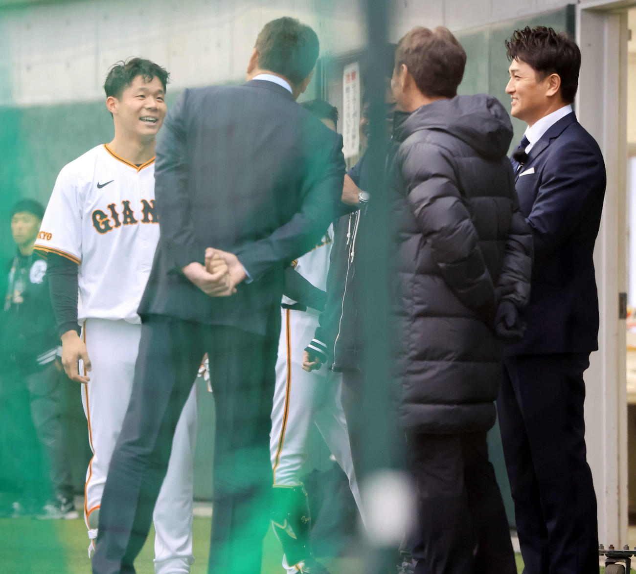 練習中、視察に訪れた高橋由伸氏（右）ら評論家陣に笑顔であいさつする佐々木（撮影・浅見桂子）