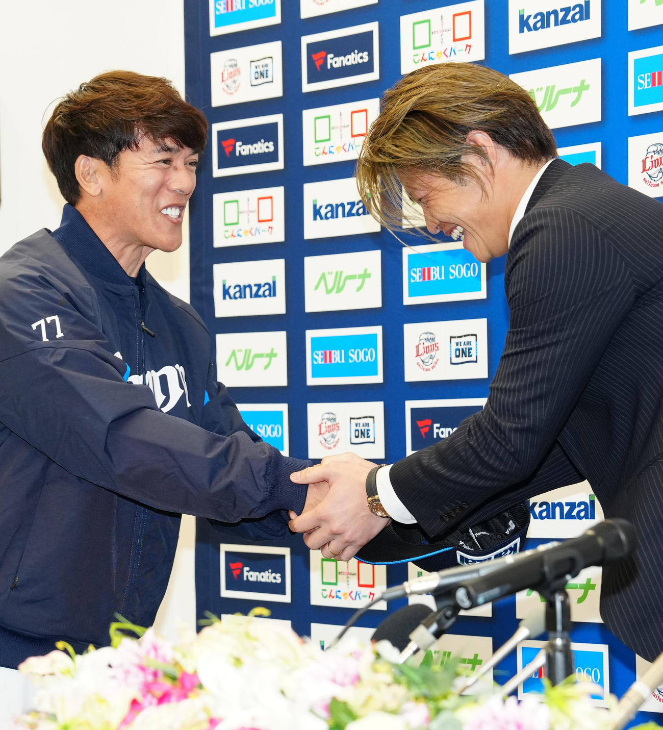 入団会見中、サプライズで登場した西武松井監督（左）と握手を交わす甲斐野（撮影・江口和貴）