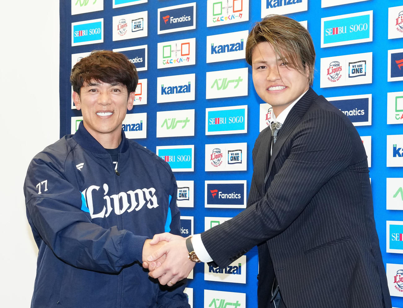 入団会見中、サプライズで登場した西武松井監督（左）と握手を交わし写真に納まる甲斐野（撮影・江口和貴）