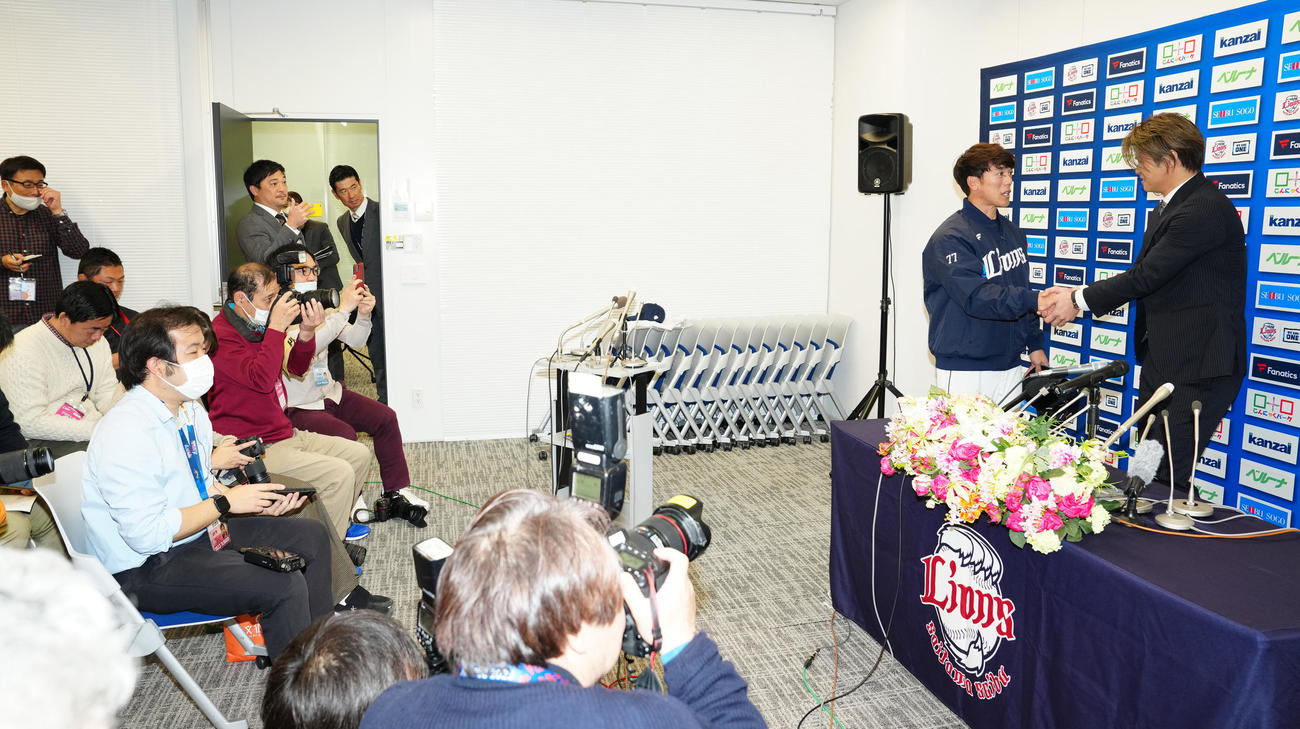 入団会見中、サプライズで登場した西武松井監督と握手を交わす甲斐野（右端）（撮影・江口和貴）