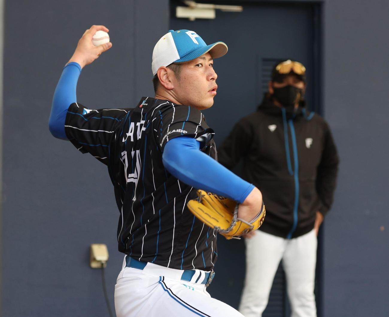 新庄監督（右）が見つめる中、ブルペンで投球する日本ハム加藤貴（撮影・黒川智章）