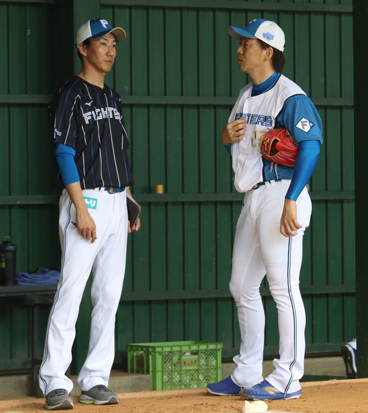 ブルペンでの投球練習後、浦野コーチと話す日本ハム宮西（右）（撮影・永野高輔）