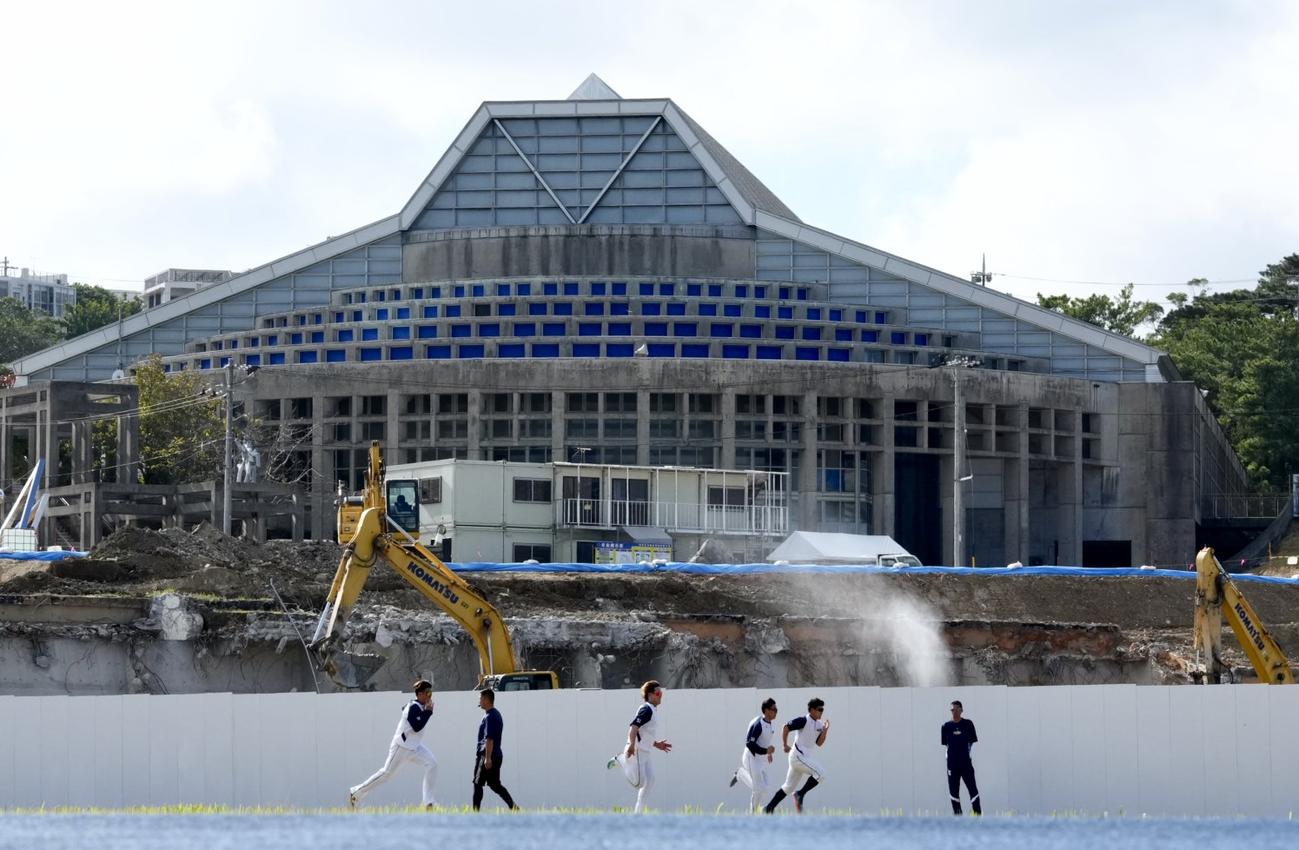 改修工事をする陸上競技場をバックにダッシュをするヤクルトナイン（撮影・横山健太）