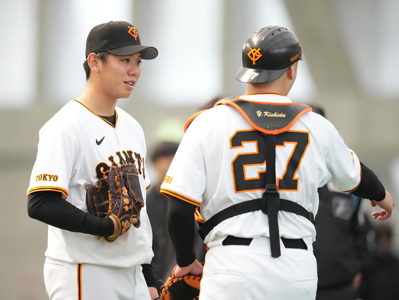 ブルペンでの投球を終え、岸田（右）と話す巨人又木（撮影・鈴木みどり）