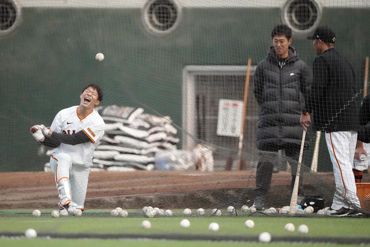 打撃練習で阿部監督（右）から直接指導を受け、苦悶（くもん）の表情を浮かべる巨人佐々木（撮影・鈴木みどり）