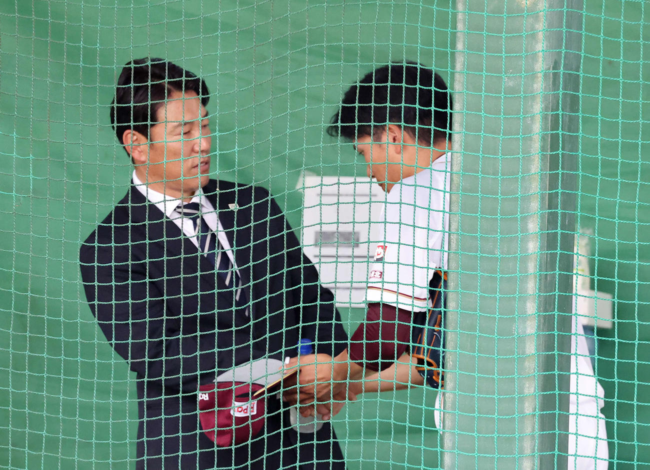 早川（右）は井端監督と握手を交わす