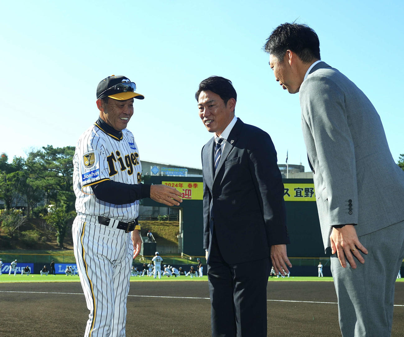 阪神春季キャンプの視察に訪れた侍ジャパン井端監督（中央）、吉見投手コーチと握手を交わす岡田監督（左）（撮影・藤尾明華）