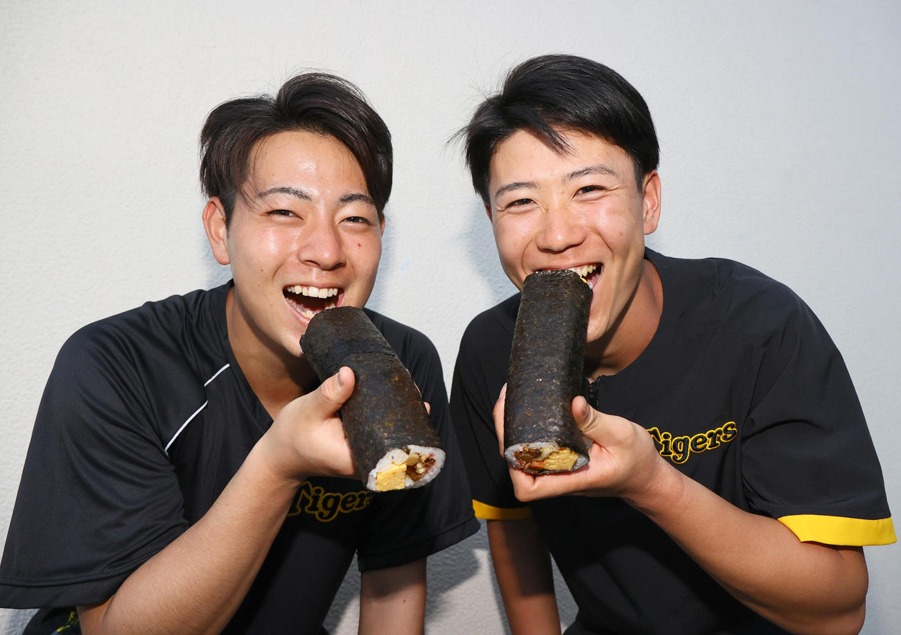 阪神下村（左）と阪神山田は恵方巻をがぶりっ！（撮影・上山淳一）