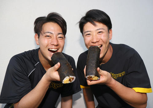阪神下村(左)と阪神山田は恵方巻をがぶりっ!(撮影・上山淳一)