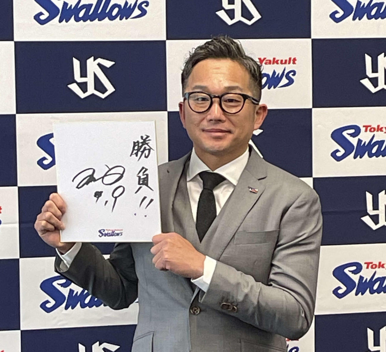 23年12月20日、契約更改を終えて色紙に「勝負」と記したヤクルト石川