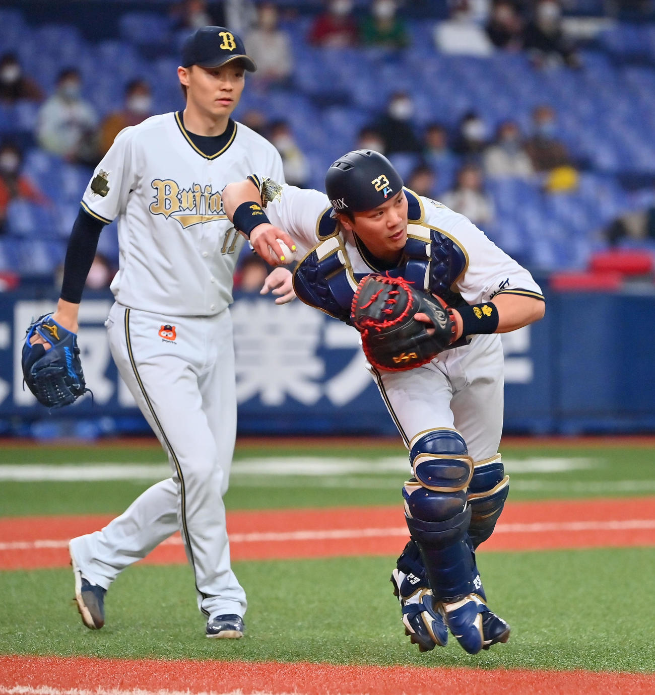 オリックス時代に、打球を軽快に処理する伏見寅威、後方は山崎福也（2022年3月撮影）