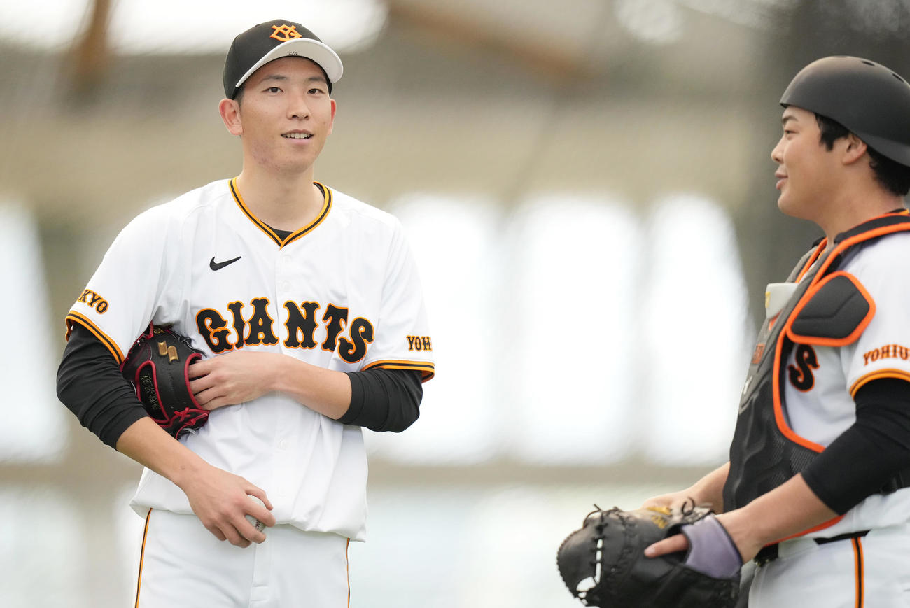 ブルペンでの投球を終え、山瀬（右）と話す巨人戸郷（撮影・鈴木みどり）