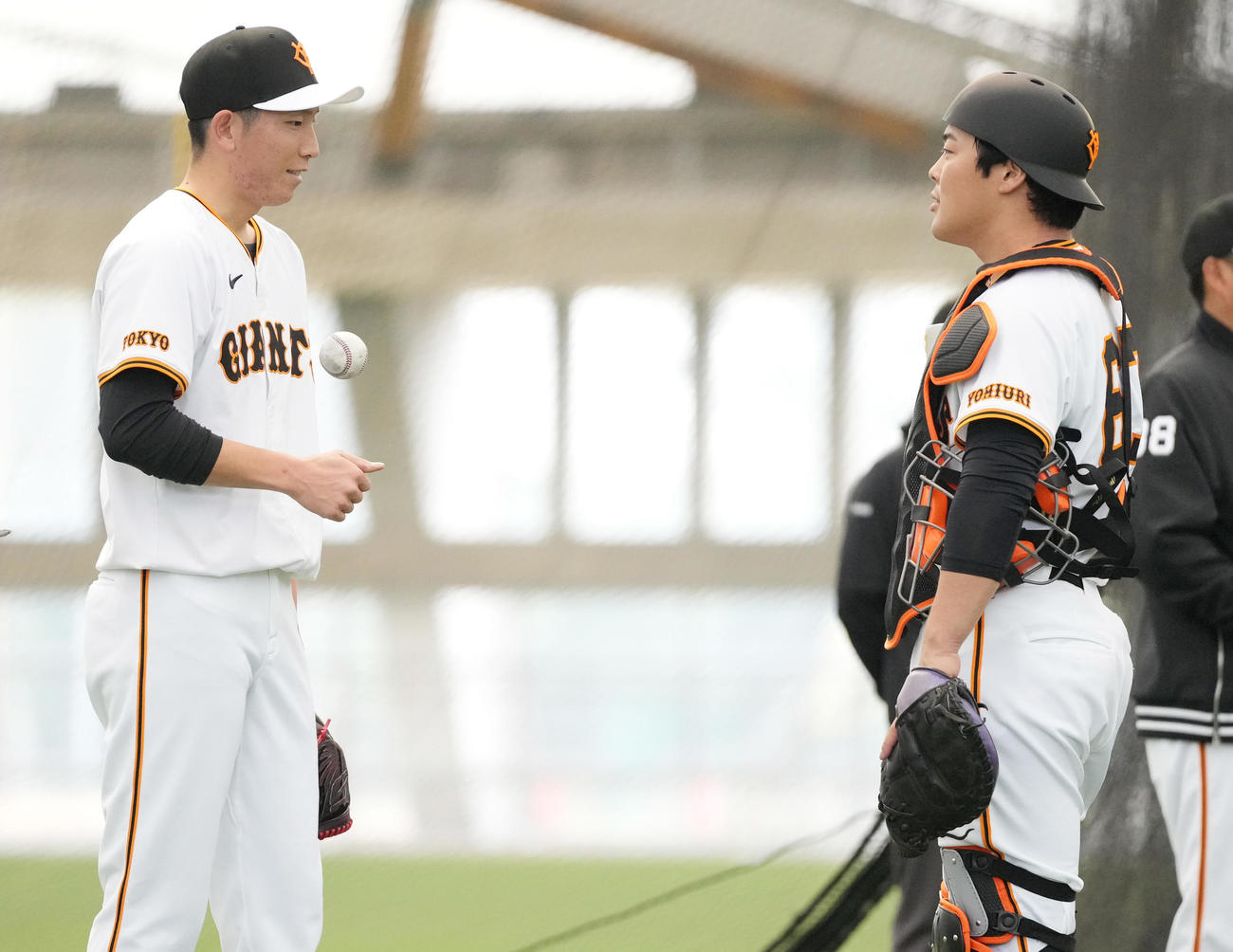 ブルペンでの投球を終え、山瀬（右）と話す巨人戸郷（撮影・鈴木みどり）