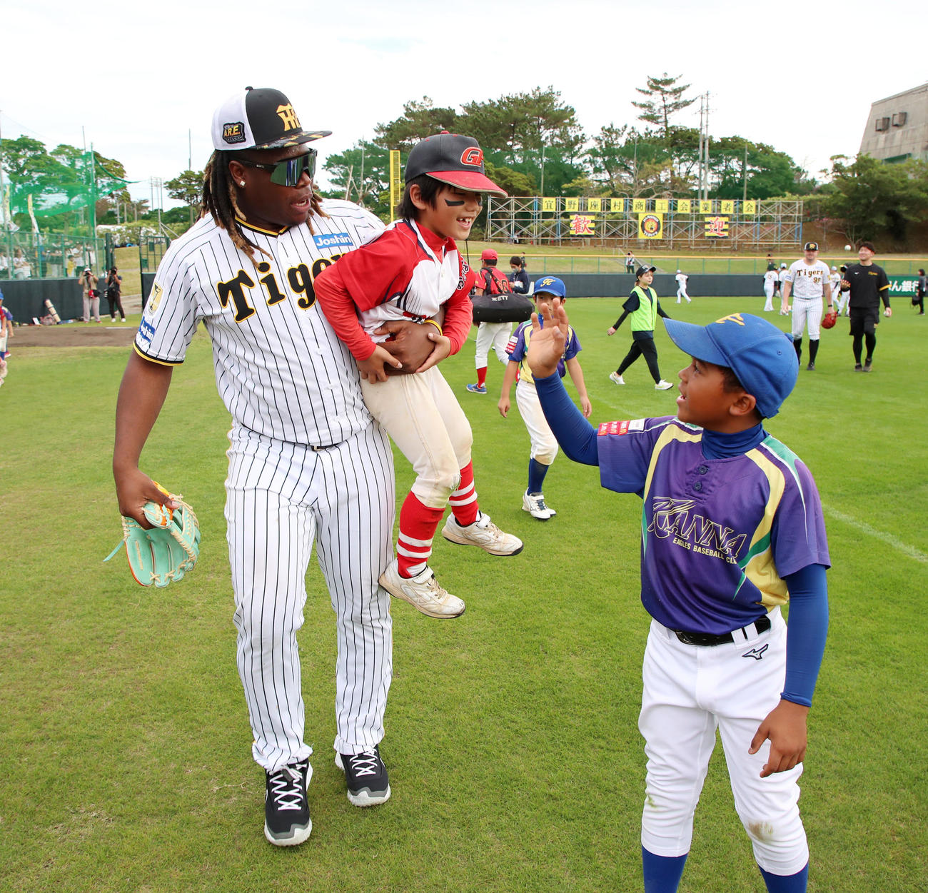 野球教室が終了し、「ドミニカへ連れて帰る」といいながら参加した子供を抱きかかえて冗談を言うミエセス（撮影・加藤哉）