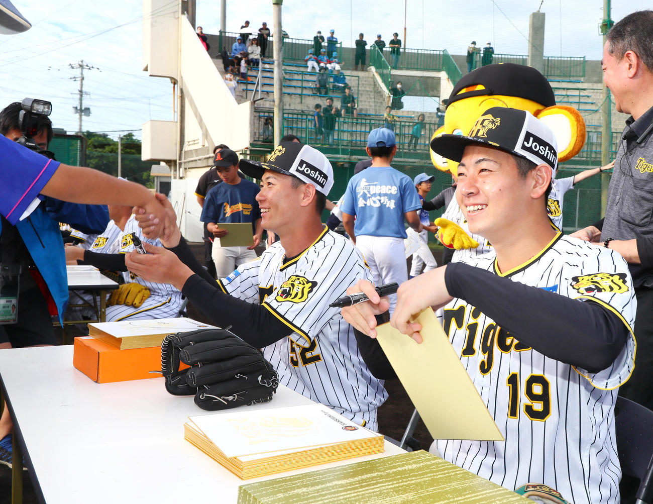 野球教室を終え、子供たちにサイン会を開き笑顔を見せる下村（右）と山田（撮影・上山淳一）
