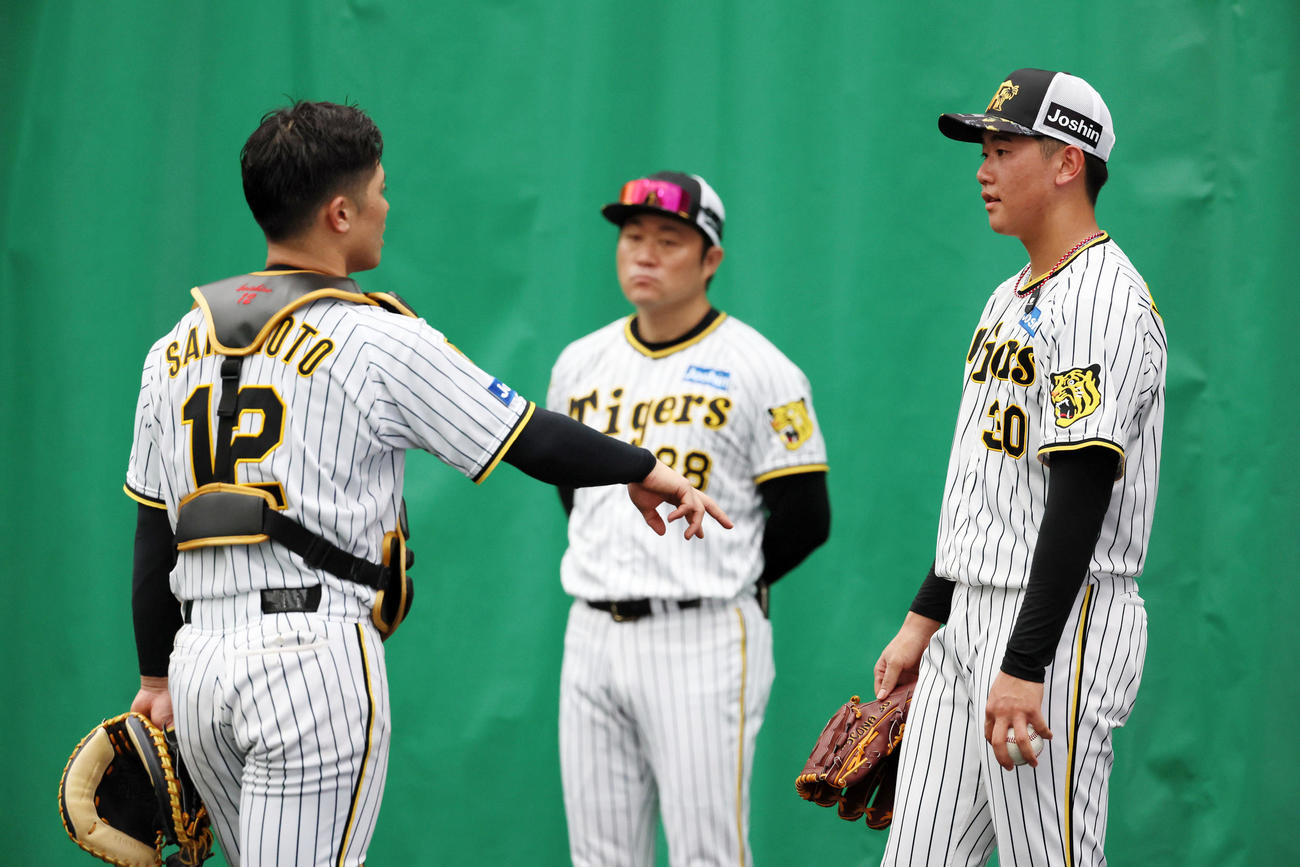 ブルペンで投球練習を終え坂本（左）と話す門別（撮影・加藤哉）