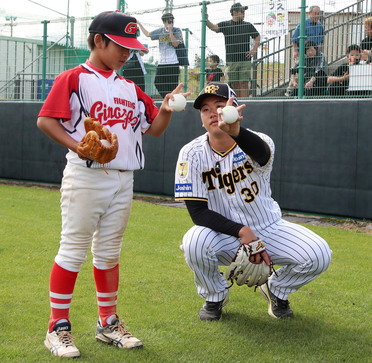 野球教室に参加した門別は子供に変化球の握りを教える（撮影・加藤哉）