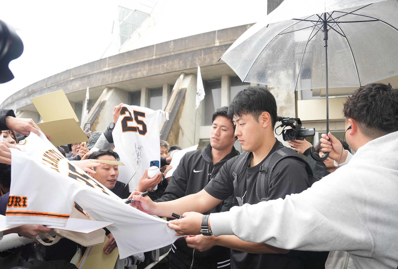 ファンにサインする巨人岡本和（撮影・鈴木みどり）