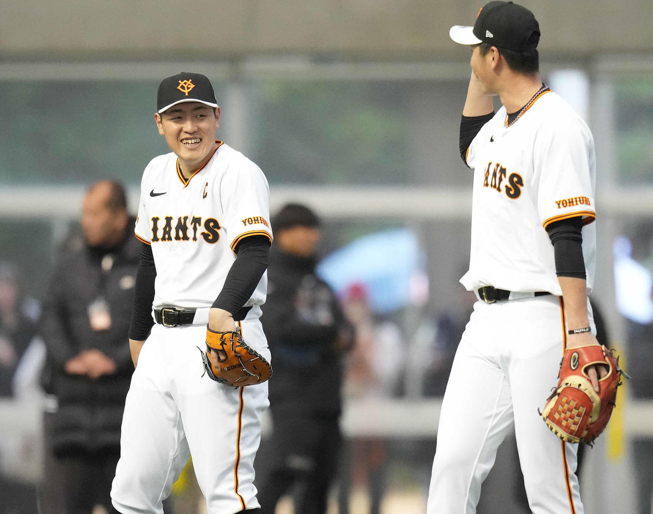 ノックの合間に笑顔の巨人岡本和。右は秋広（撮影・鈴木みどり）