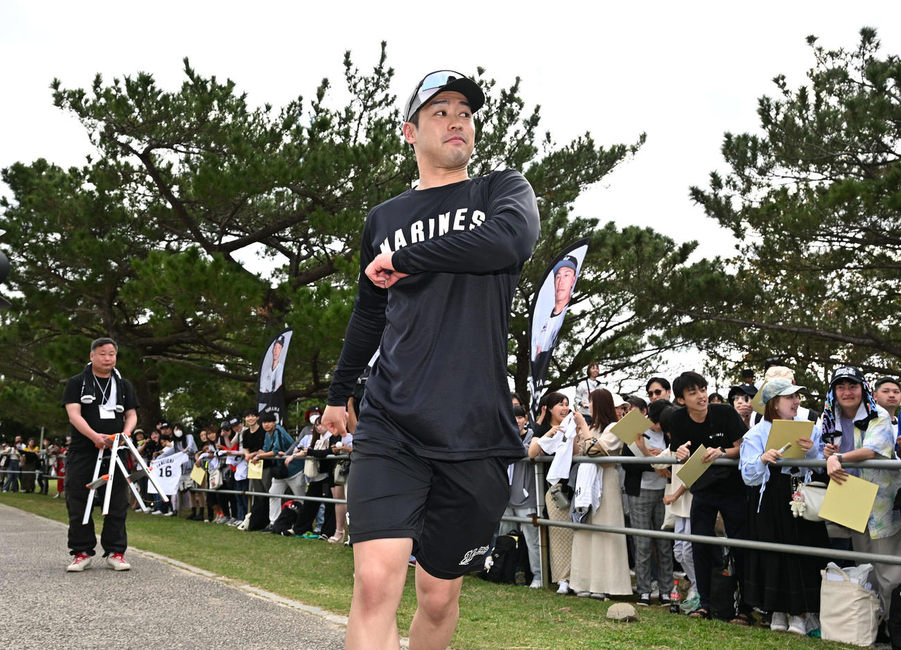 帰り間際にファンのサインに応じ、引き揚げようとするロッテ種市。ファンを背に引き揚げる姿を撮影しようとするも、サインを求める声に方向転換。再びファンサービスを始めました。青森県出身者は優しいんです（撮影・滝沢徹郎）