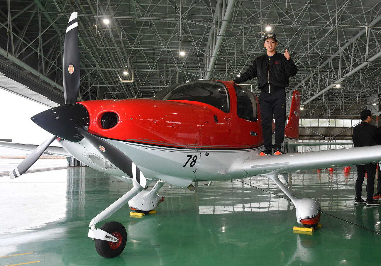 キャンプ休日の新人体験で航空大学校を訪れ、訓練機の上でサムアップポーズを決めるソフトバンク前田悠（撮影・岩下翔太）