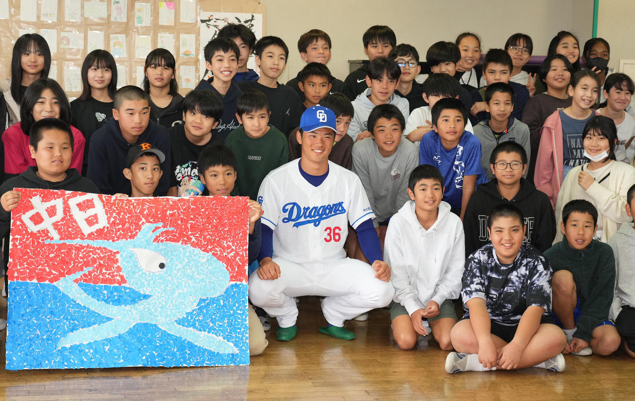キャンプ休日を利用し地元小学校の児童たちと給食時間を過ごし記念撮影をする福田（前列・中央）（撮影・森本幸一）