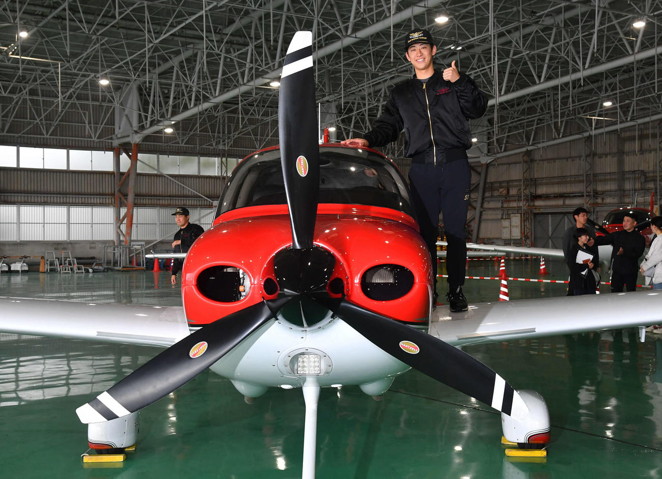 キャンプ休日の新人体験で航空大学校に訪れ、訓練機の上でポーズを決めるソフトバンク大山（撮影・岩下翔太）